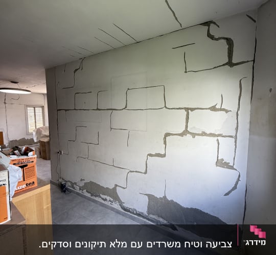 קיר עם תיקוני טיח והכנה לצביעה